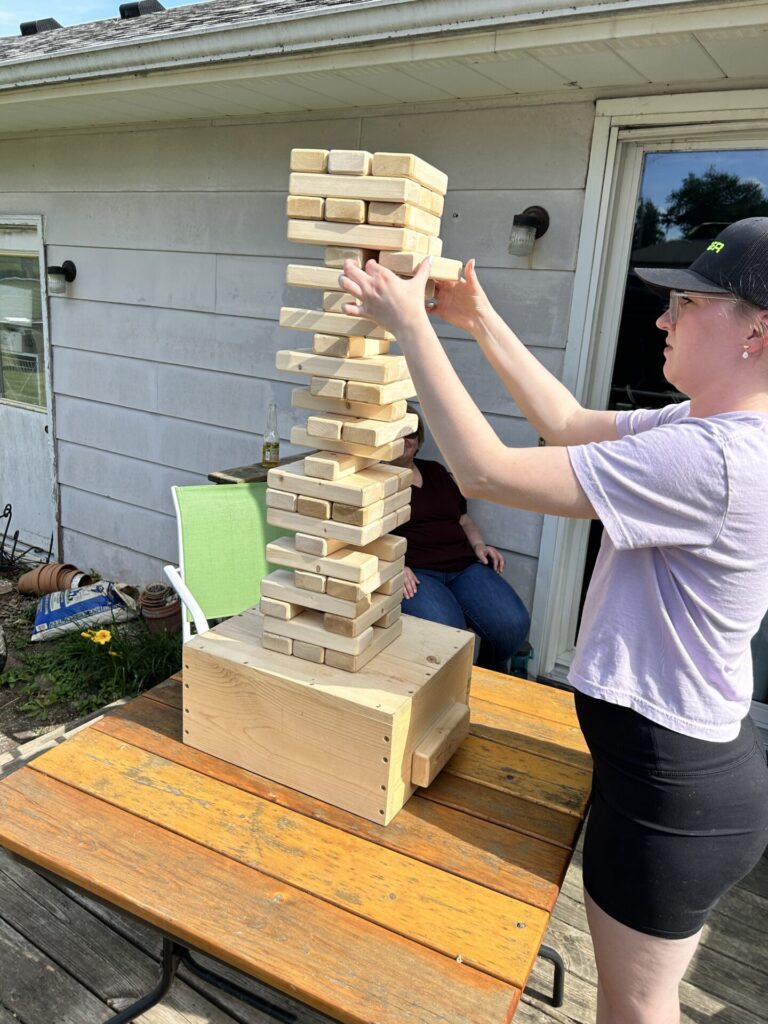 Playing Outdoor Jenga on a deck table